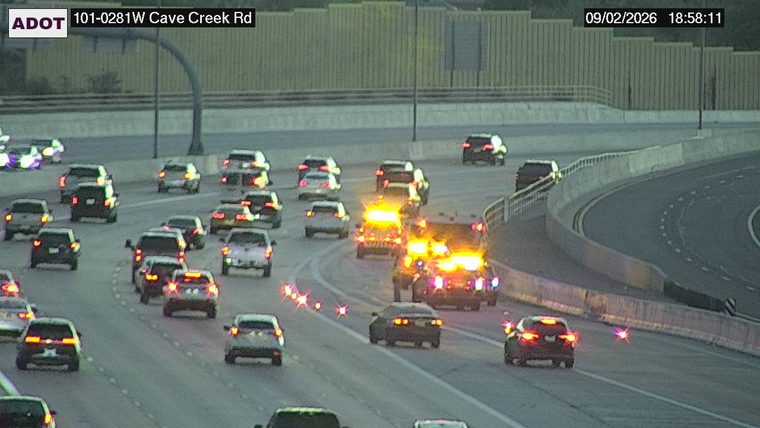 Two vehicles with flashing amber lights stopped in the right lane