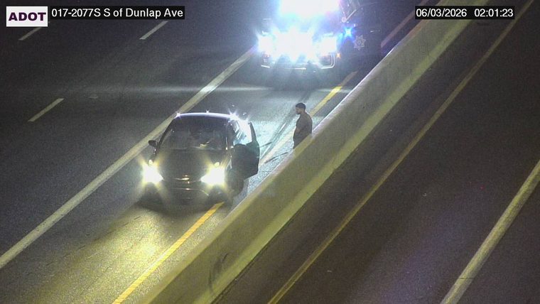 Person standing next to a vehicle in the right lane