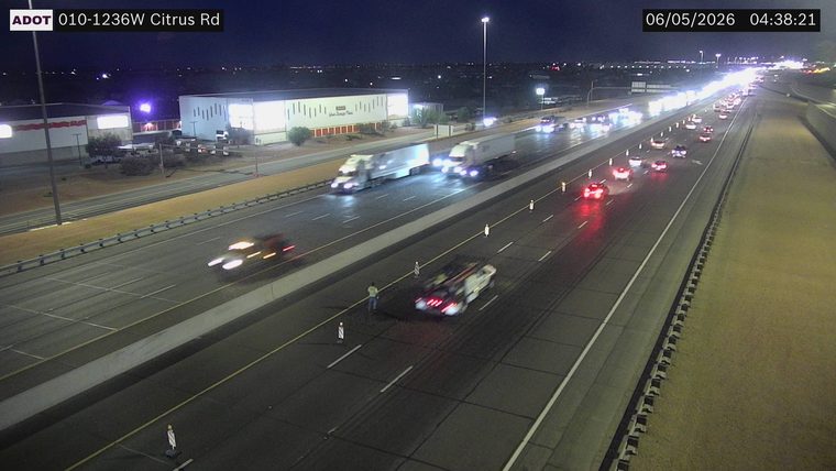 Tow truck with hazard lights on and two people standing in the right lane