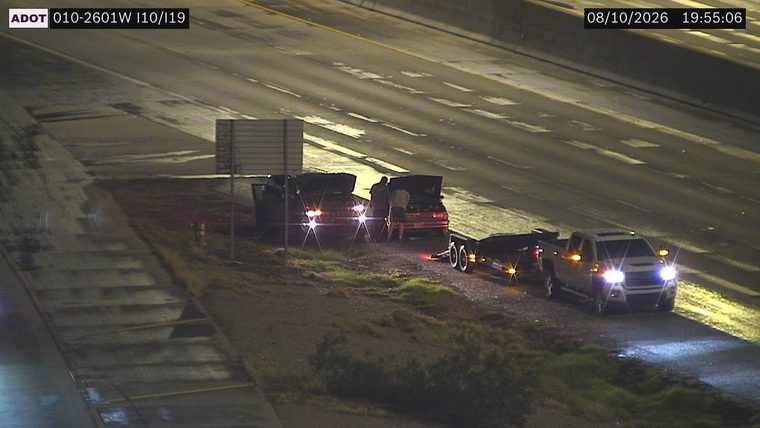 Two vehicles with hoods open on the right shoulder