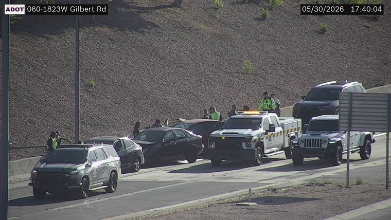 Tow truck and several vehicles with people standing around them in the right lane