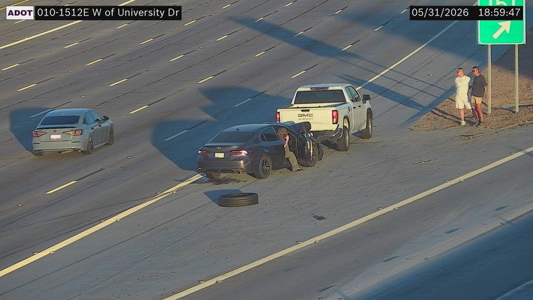 Sedan with open door and detached tire in the right lane