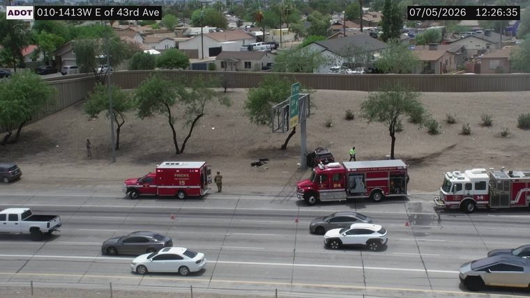 Dark colored SUV off the roadway with a person standing nearby