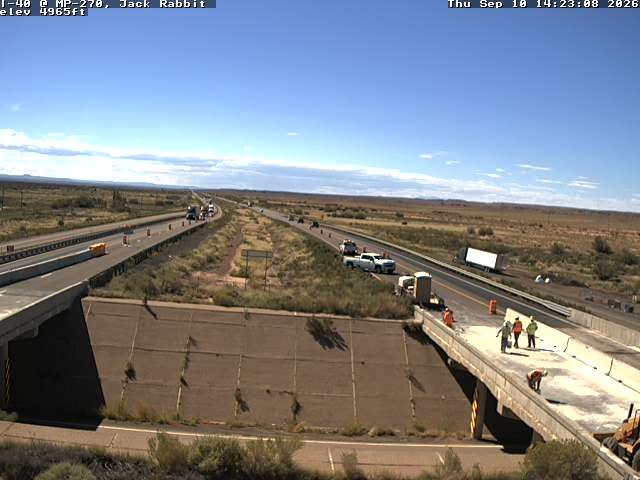 Construction workers and equipment on the right side of the roadway