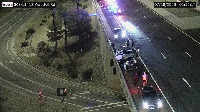 Multiple emergency vehicles and personnel on the right shoulder