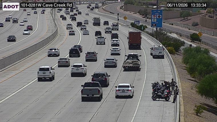 Three officers and a motorcycle on the right shoulder