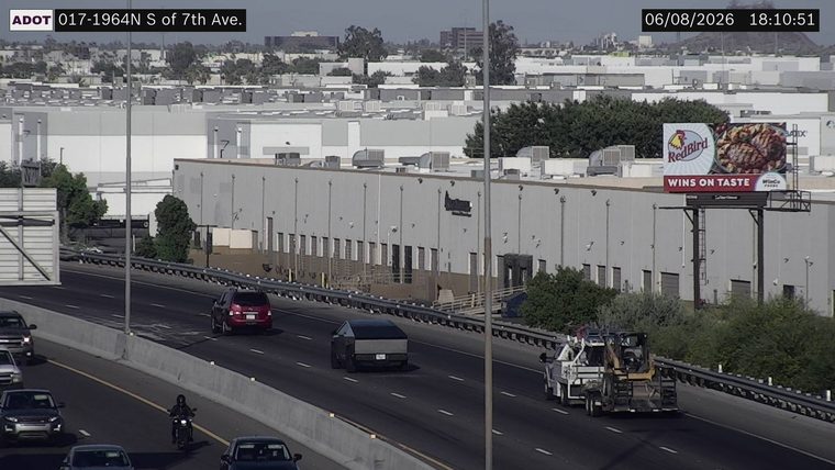 Tow truck with a skid steer loader on the right lane
