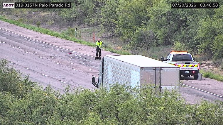 Motorist Assistant truck with amber lights on the right shoulder, and a person sweeping debris in the left lane