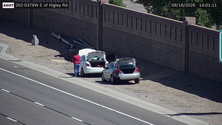 Two vehicles on the right shoulder with open trunks