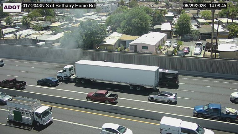 Car on fire in the right lane with smoke and a fire truck present