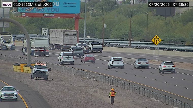 White pickup truck with flashing amber lights on the right shoulder