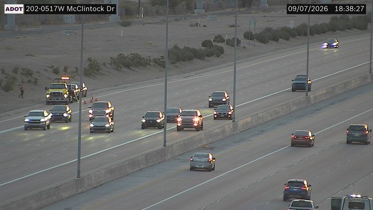 Tow truck with hazard lights on and cones on the right shoulder