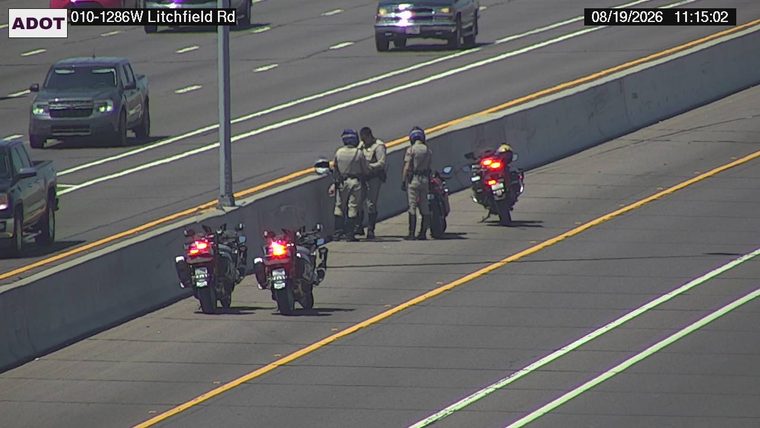 Three officers and two motorcycles on the right shoulder