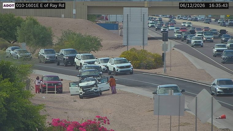 White vehicle with visible front-end damage and open doors on the shoulder