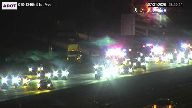 Multiple emergency vehicles with red and blue lights on the roadway