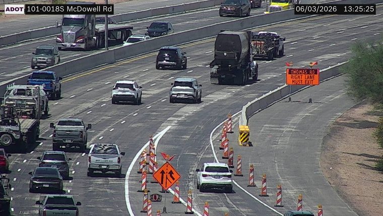 Construction cones and a 'Thomas Rd Right Lane Must Exit' sign in the right lane