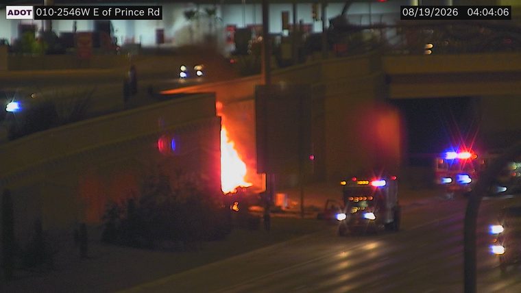 Fire on the side of the overpass with emergency vehicles present