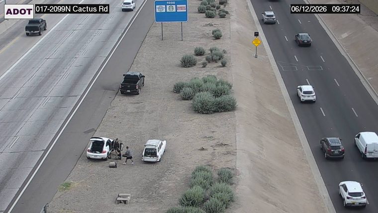 Two people and two vehicles on the shoulder
