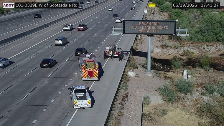 Fire truck and police vehicle on the right shoulder with personnel present
