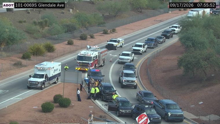 Two vehicles collided in the left lanes with visible damage and emergency responders present