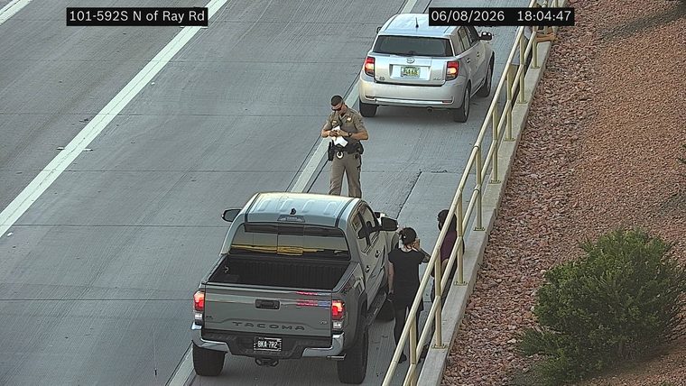 Police officer interacting with occupants of a pickup truck on the shoulder