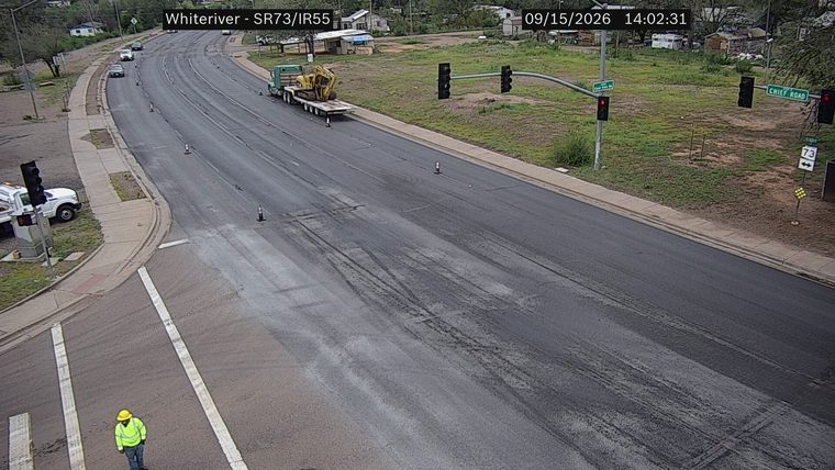 Worker in high-visibility vest and hard hat in the left lane