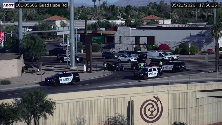 Multiple police vehicles with flashing lights and officers on scene at a multi-vehicle crash at the intersection of Guadalupe Road