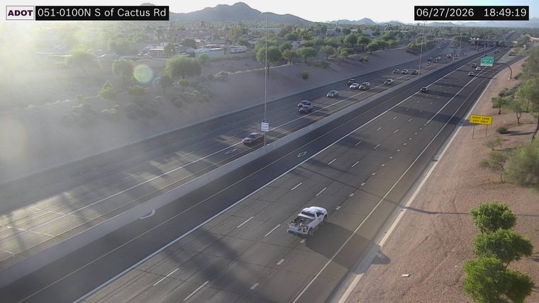 White vehicle with hood open on the right shoulder