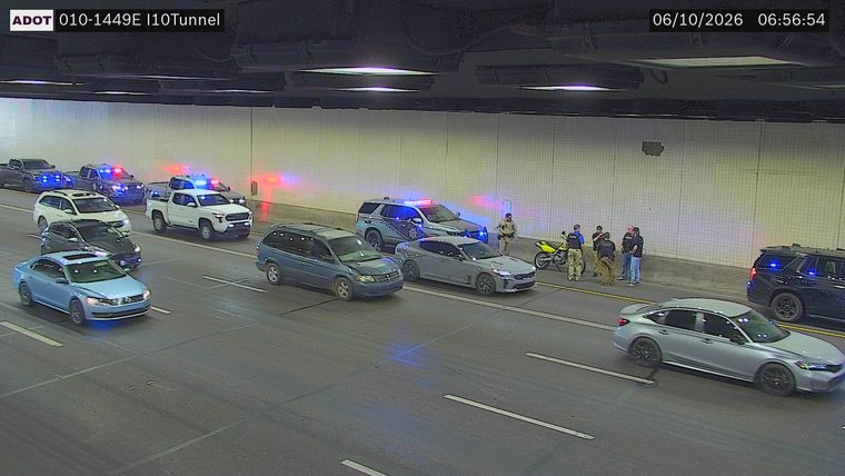 Multiple police vehicles and officers with a motorcycle on the right shoulder