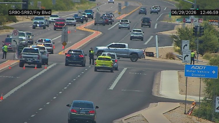 Police car with lights on in the left lane, directing traffic