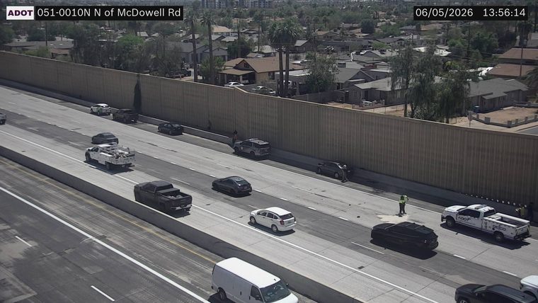 ADOT truck and two individuals in the right lane near a black SUV