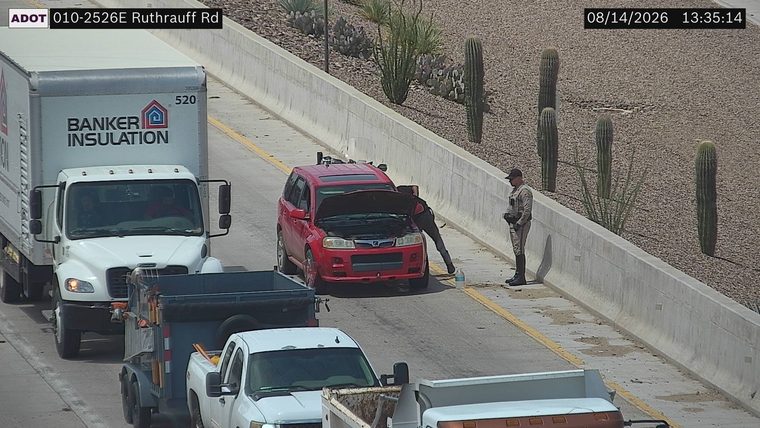 Person attending to red SUV with hood open on the right shoulder