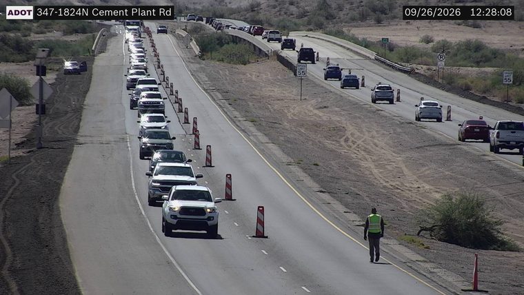 Person in high-visibility vest walking on the shoulder