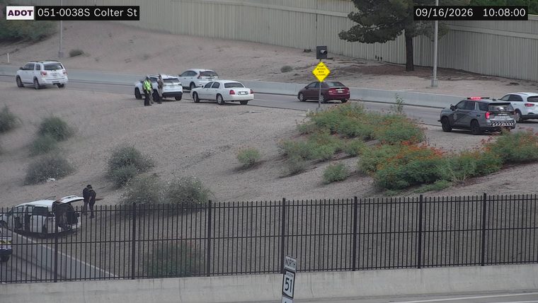 Police car with red and blue lights on the right shoulder