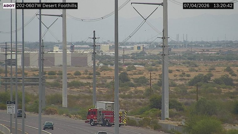 Fire truck with red flashing lights on the right shoulder