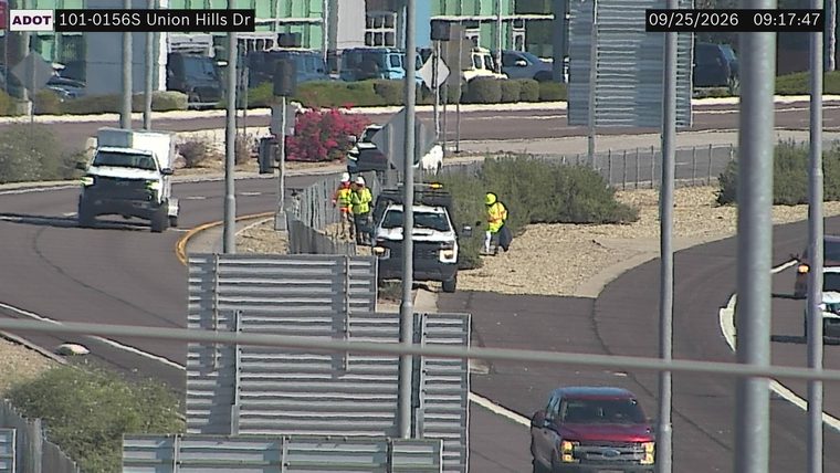 Construction workers and a vehicle on the right shoulder