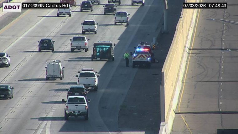 Police car with red and blue lights on the right shoulder