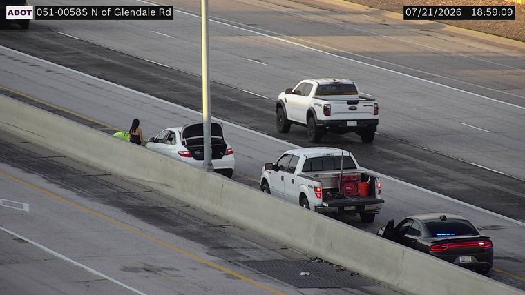 Woman and a white car on the left shoulder