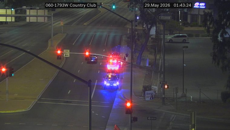Two police cars with lights on in the left lane