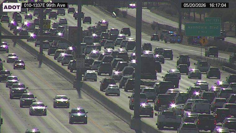 Police vehicle with flashing lights on the right shoulder near the Avondale Blvd sign