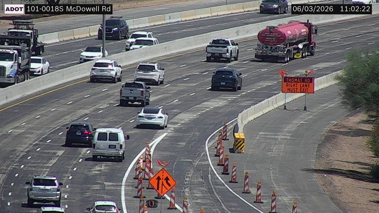 Construction cones and a sign indicating 'THOMAS RD RIGHT LANE MUST EXIT'