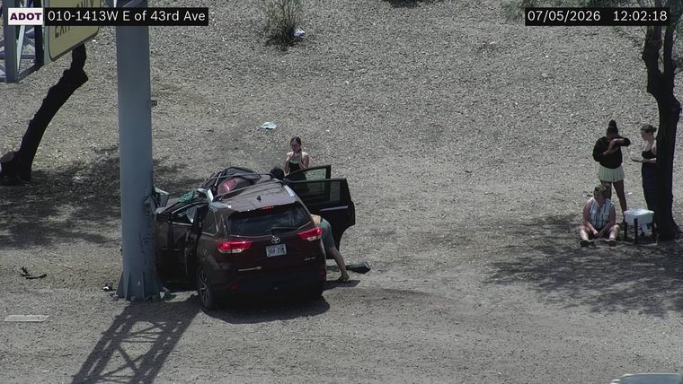 SUV crashed into a pole with visible damage, people standing around the vehicle
