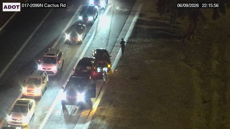 Fire truck and two vehicles in the right lane with people standing nearby