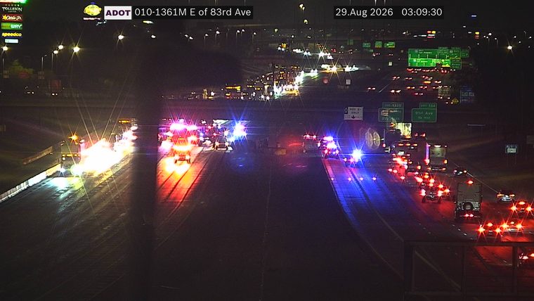 Multiple emergency vehicles with red and blue lights on the right shoulder