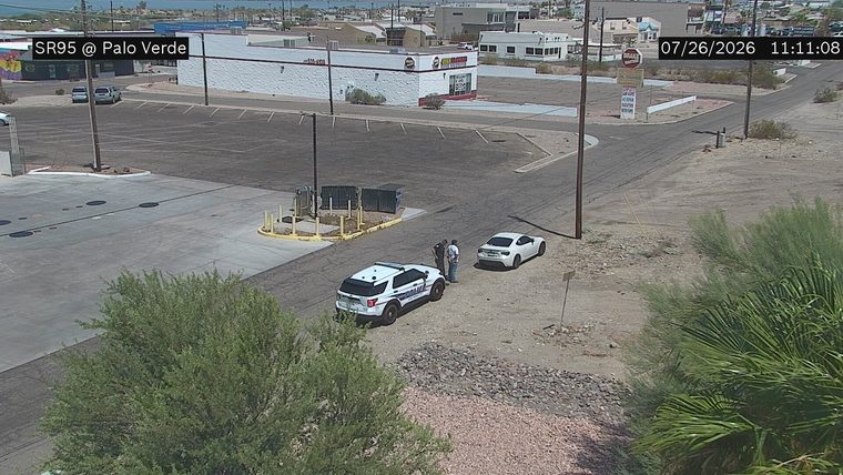 Police car and two individuals on the side of the road