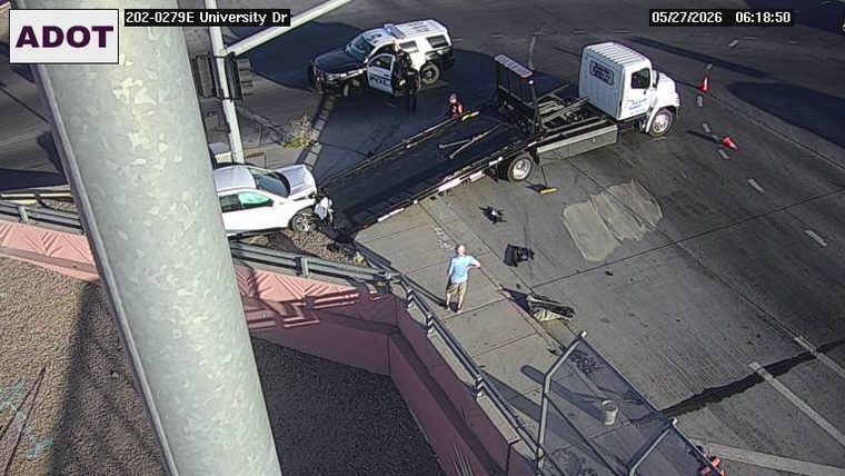 A white SUV crashed into the guardrail with a tow truck and police vehicle responding on the shoulder