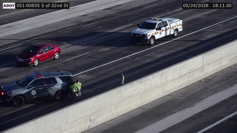 State Trooper SUV with emergency lights on and responders standing on the left shoulder next to the concrete barrier