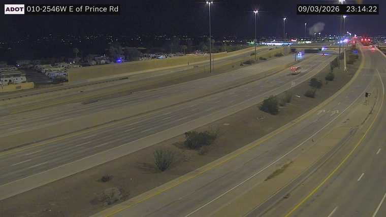 Multiple emergency vehicles with red and blue lights on the right shoulder