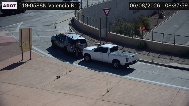 Police SUV with lights on and a person standing between it and a white pickup truck