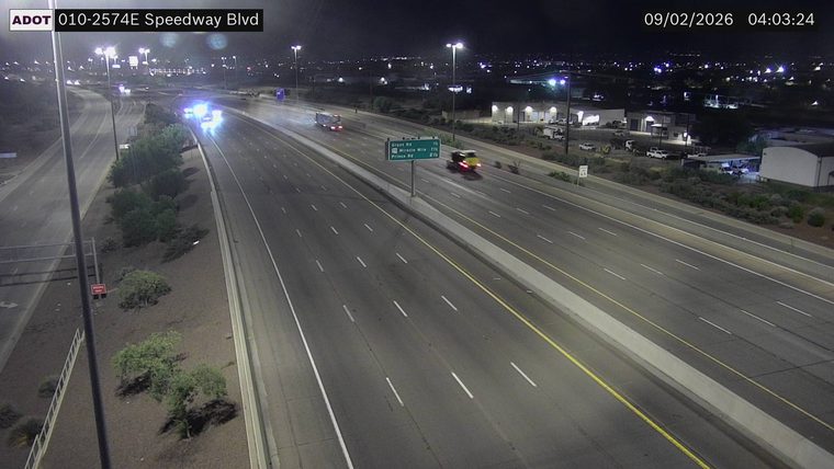 Two vehicles with flashing blue and red lights on the left shoulder